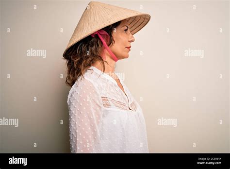 Middle Age Brunette Woman Wearing Asian Traditional Conical Hat Over