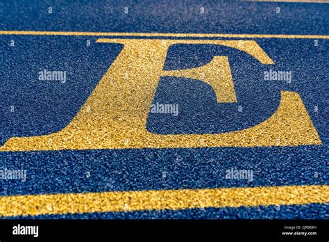 Close Up The Letter Initial E On A New Blue Running Track With Yellow