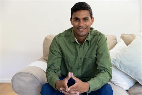 Premium Photo Portrait Of Happy Biracial Man Sitting On Sofa At Home