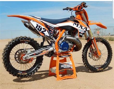 An Orange Dirt Bike Parked On Top Of A Stand