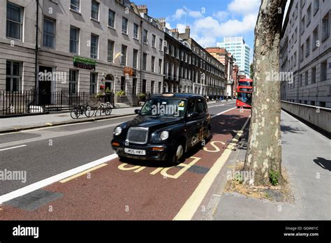 London Black Cab Taxi And Red Double Decker Bus Using The Bus Lane