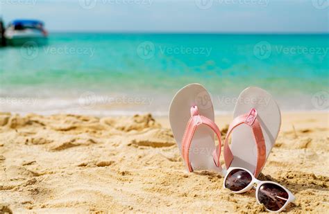 Pink And White Sandals Sunglasses On Sand Beach At Seaside Casual Fashion Style Flipflop And