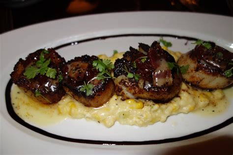 Blackened Scallops Topped With Pepper Bacon And Tomato Jam On A Bed Of