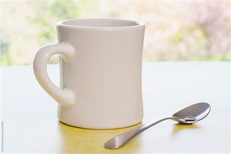 "Retro Coffee Mug And Spoon On Diner Counter Near Window" by Stocksy Contributor "David Smart ...