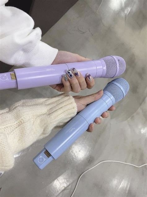 A Woman Holding A Purple And Blue Hair Dryer In Her Hand While Another