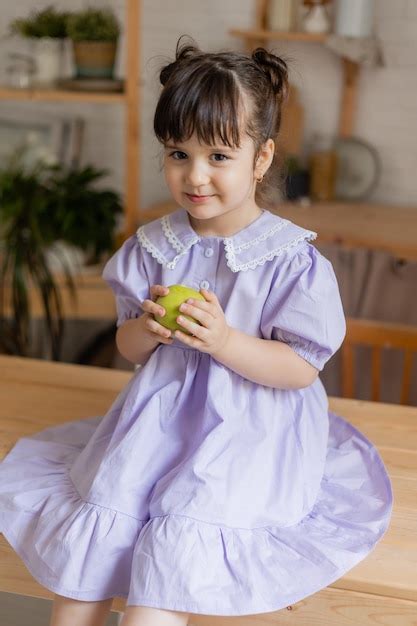 Una Ni A Encantadora Con Un Vestido Lila Come Una Manzana Verde En La