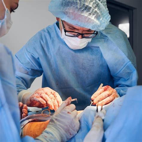 Médecin et assistant faisant une chirurgie d abdominoplastie en salle d