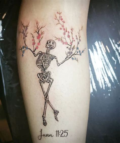 A Tattoo With A Skeleton And Flowers On Its Arm That Reads Jean 1235