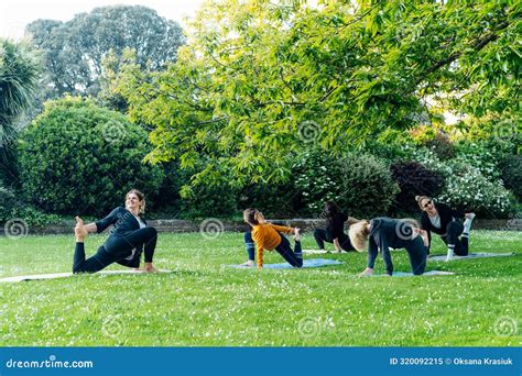 Female Yoga Class In Park Women Stretching Legs Making Low Lunge Or