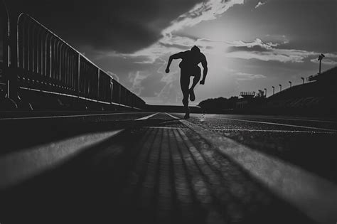 Premium Photo A Man Running Down A Street Next To A Bridge