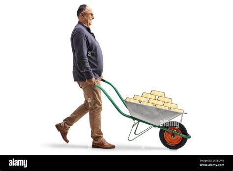 Full Length Profile Shot Of A Mature Man Pushing A Wheelbarrow With