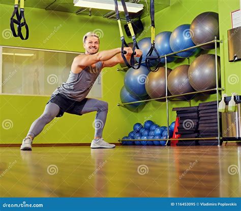 Blond Athletic Male Doing Trx Straps Exercises in a Gym Club. Stock ...