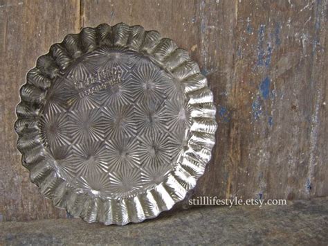 A Silver Plate Sitting On Top Of A Wooden Table Next To A Wall With