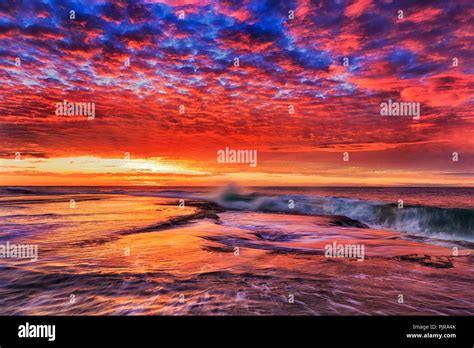 Vivid Colourful Sunrise Over Sandstone Rock Plateau At Mona Vale Beach