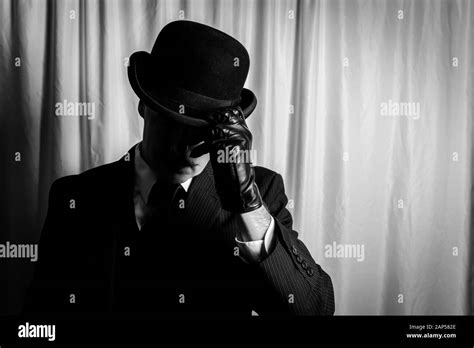 Portrait Of Man In Dark Suit And Leather Gloves Doffing Bowler Hat