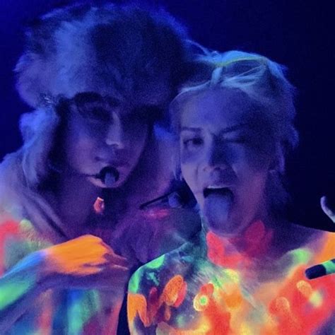 Two Women With Glow Paint On Their Body In Front Of A Microphone And