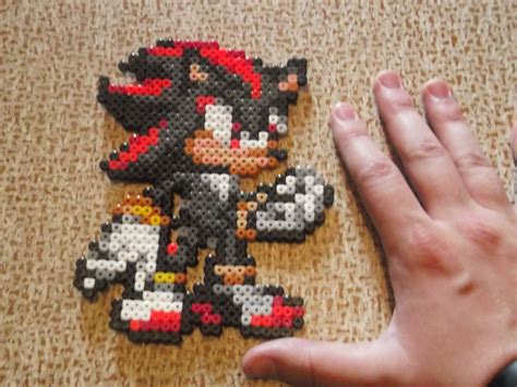 A Hand Is Next To A Piece Of Pixel Art That Looks Like Sonic The Hedgehog