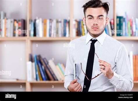 Serious Brunette Man Wearing In White Shirt And Tie Posing With