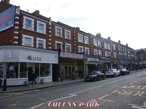 Cars Are Parked On The Street In Front Of Shops