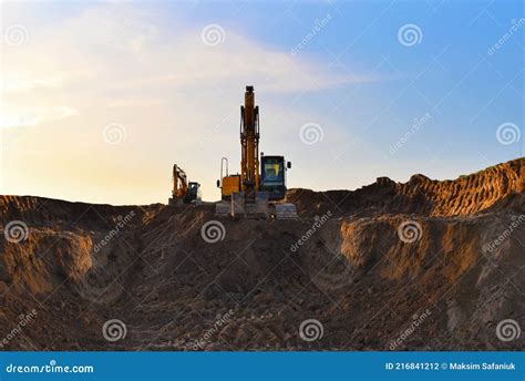 Excavator Working On Earthmoving At Open Pit Mining On Sunset Background Backhoe Digs Sand And