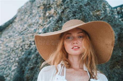 Portrait Of A Young Red Haired Woman With Freckles In A Straw Hat On