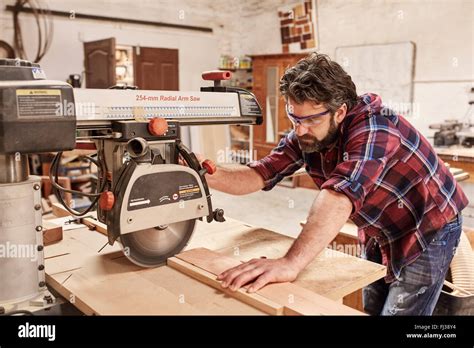 Carpenter Using Radial Arm Saw To Cut Wood In Workshop Stock Photo Alamy