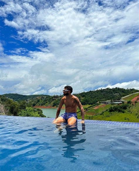 A Man Sitting On The Edge Of A Swimming Pool