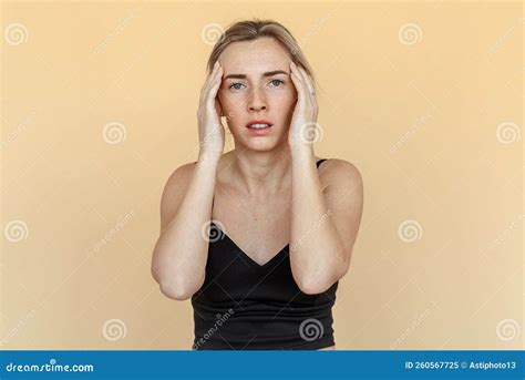 Portrait Of The Shocked Anxious Young Woman In Panic Holding Hands On Head And Worrying