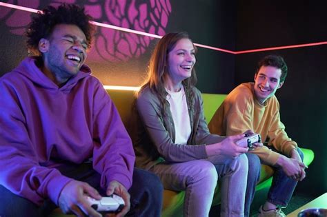 Amigos Sonrientes De Tiro Medio Jugando Videojuegos Foto Gratis