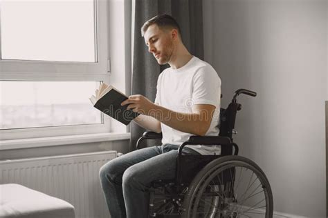 Discapacitado En Silla De Ruedas Leyendo Un Libro En Casa Foto De