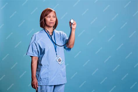 Premium Photo Elderly Asian Nurse In Blue Uniform Holding Medical