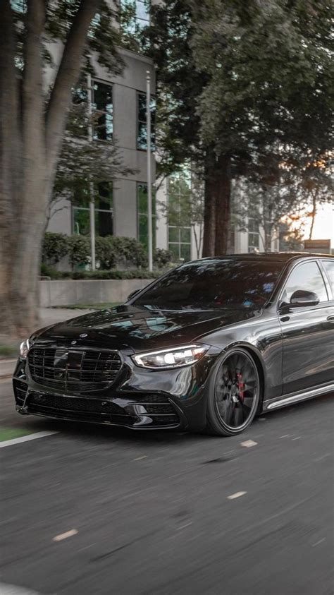 A Black Mercedes S Class Driving Down The Street