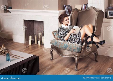 Beautiful Brunette Rich Saucy Woman In Elegant Dress Sitting On A Chair