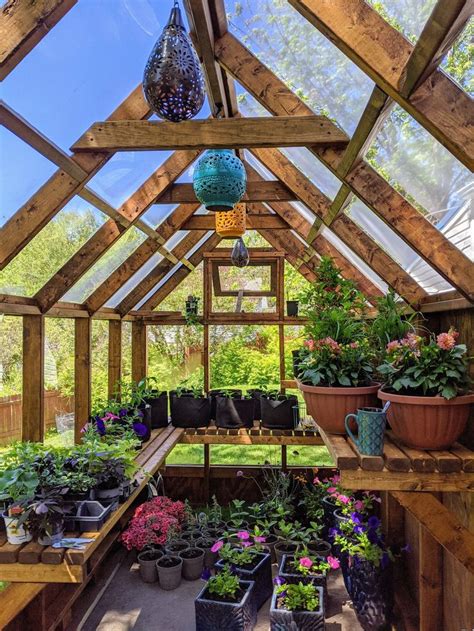 An Indoor Greenhouse With Potted Plants And Hanging Lights On The