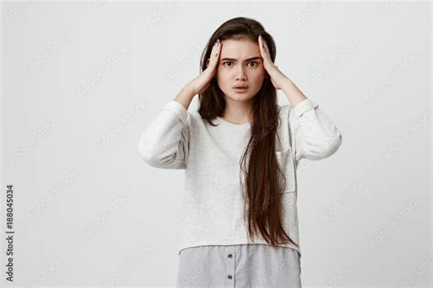 Clueless Brunette Girl In Casual Clothes Looking At Camera With Irritated And Puzzled Expression