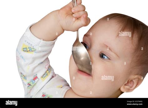 Baby Girl Holding Spoon In Mouth Isolated On White Stock Photo Alamy