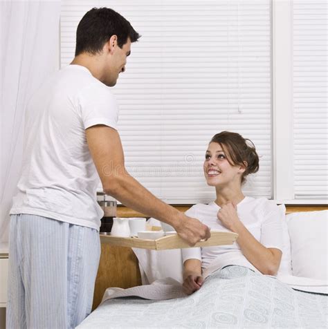 Desayuno Femenino De La Porción Masculina En Cama Foto De Archivo