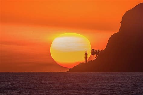 Lighthouse on cliff with glowing orange sunset Photograph by David Fong - Fine Art America