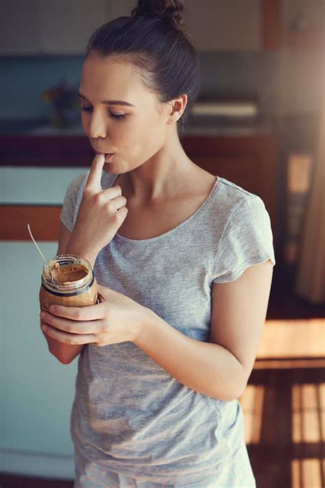 Peanut Butter On Her Fingertips An Attractive Young Woman Eating