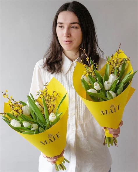 The Woman Is Holding Two Bouquets Of Flowers