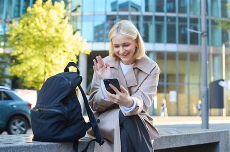 Portrait D une Jeune étudiante Blonde Assise Sur Un Banc De Rue En Attente De Quelqu un Tenant