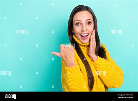 Photo Of Sweet Excited Woman Wear Yellow Sweater Arm Cheek Pointing