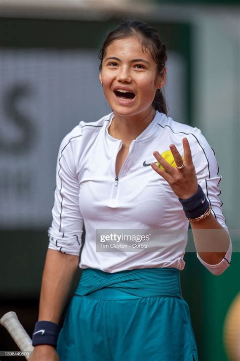 A Woman Holding A Tennis Racquet On Top Of A Tennis Court With Her