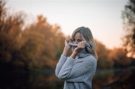 Charmante Femme Blonde Debout Près De La Rivière Dans La Forêt En Détournant Les Yeux En