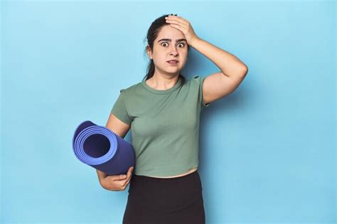 Premium Photo Sporty Woman With Yoga Mat On Blue Being Shocked She