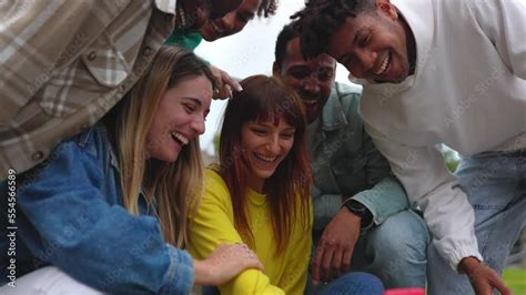 Young Multiracial Friends Having Fun Looking At Mobile Phone Screen