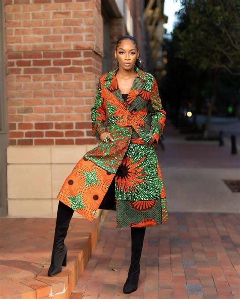 A Woman Standing On Steps Wearing An Orange And Green Coat