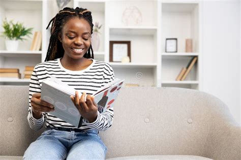 Afro American Woman Enjoying Leisure Time Reading At Home Stock Photo