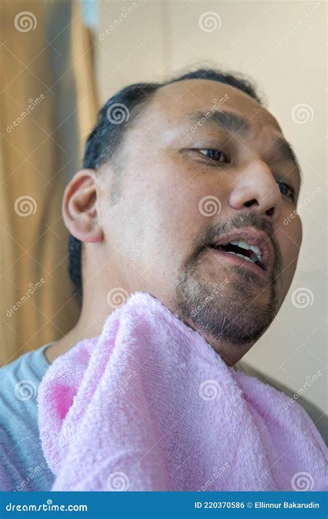 Asian Man Wiping Face With Pink Towel Cleaning Shaving Foam On The