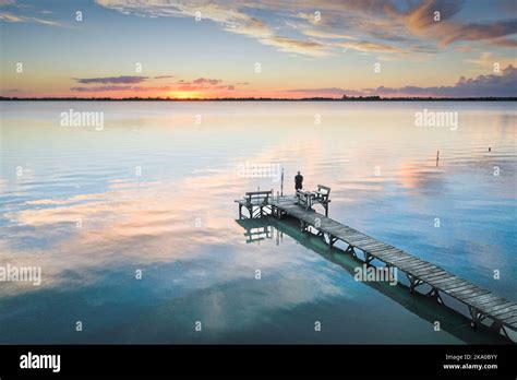 Lonely Man Watching Sunset At Lake On The Pier Stock Photo Alamy